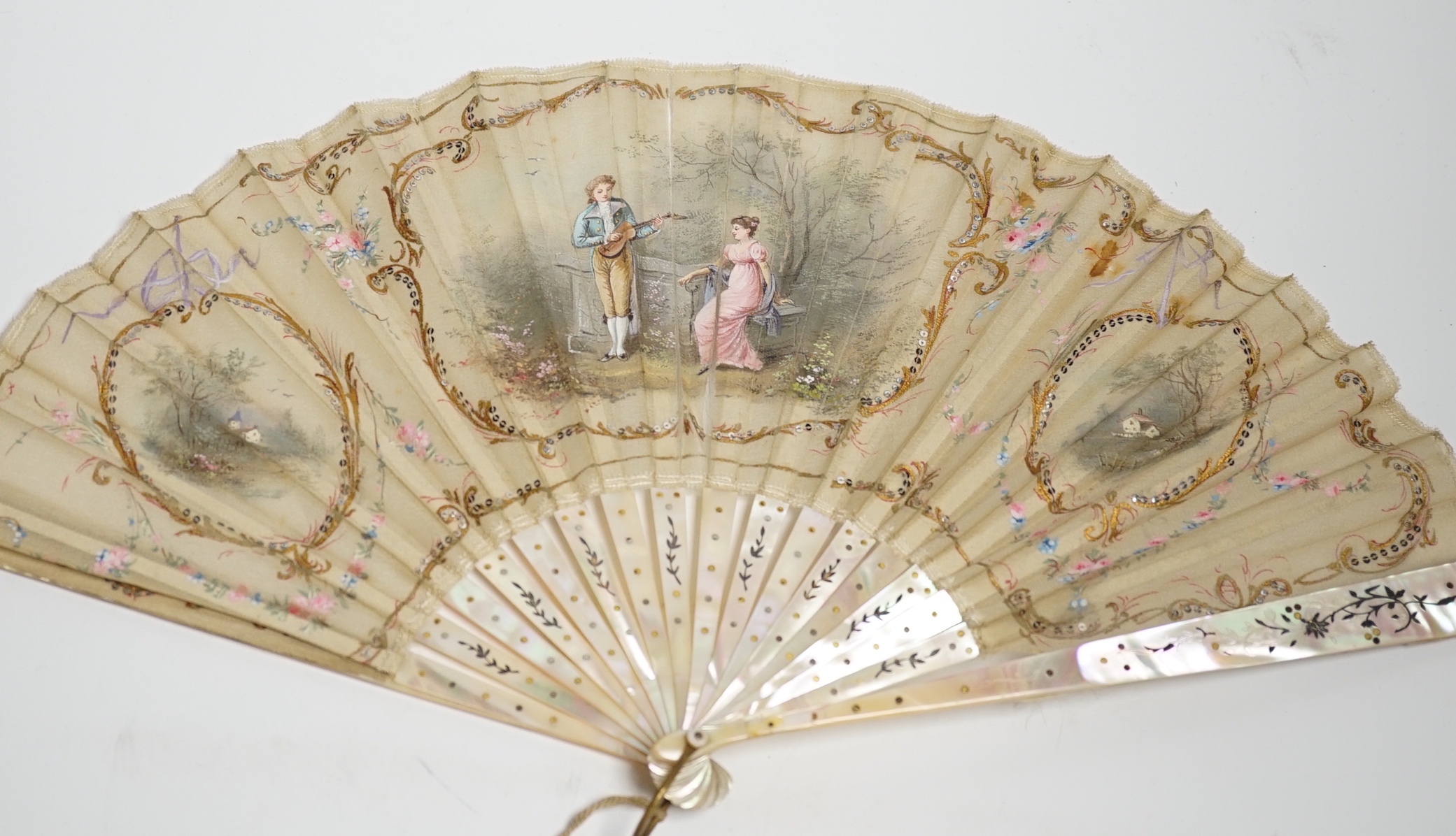 An Edwardian mother of pearl and fine gauze hand painted fan in satin and sequin case